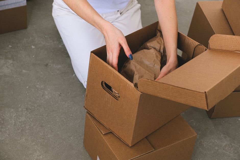 Movers providing packing services with cardboard boxes